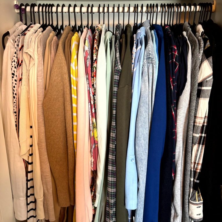 Ein Kleiderständer mit verschiedenen Shirts und Pullovern in mehreren Farben.