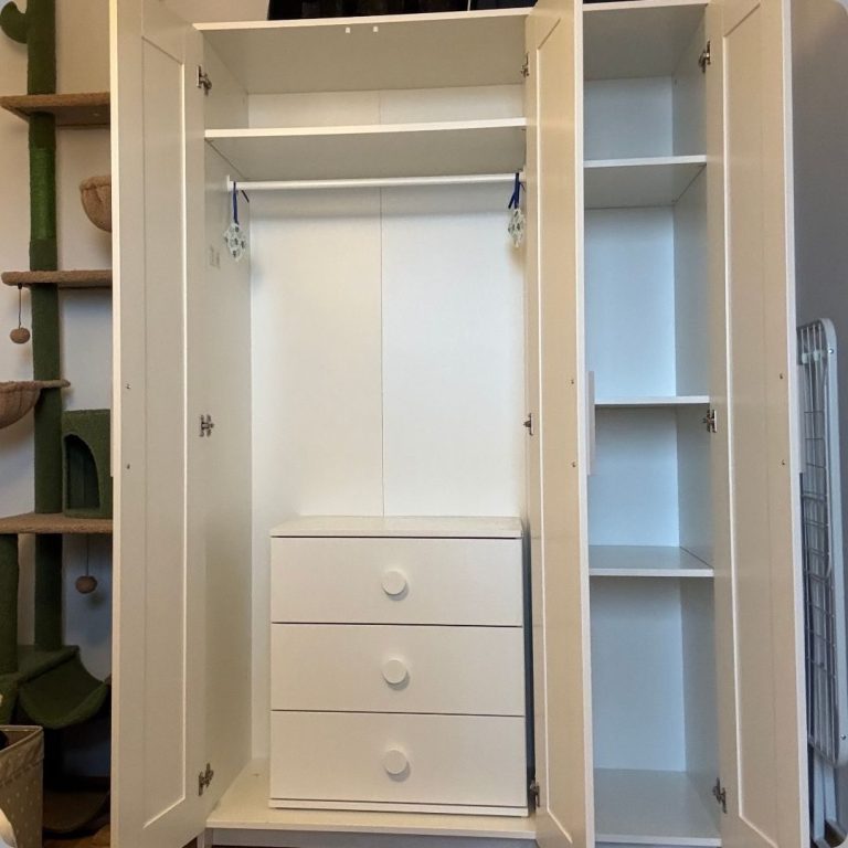 Weißer Kleiderschrank mit zwei Türen, einem Kleiderstangenbereich und Schubladen, sowie einer Tür mit 3 Fächern